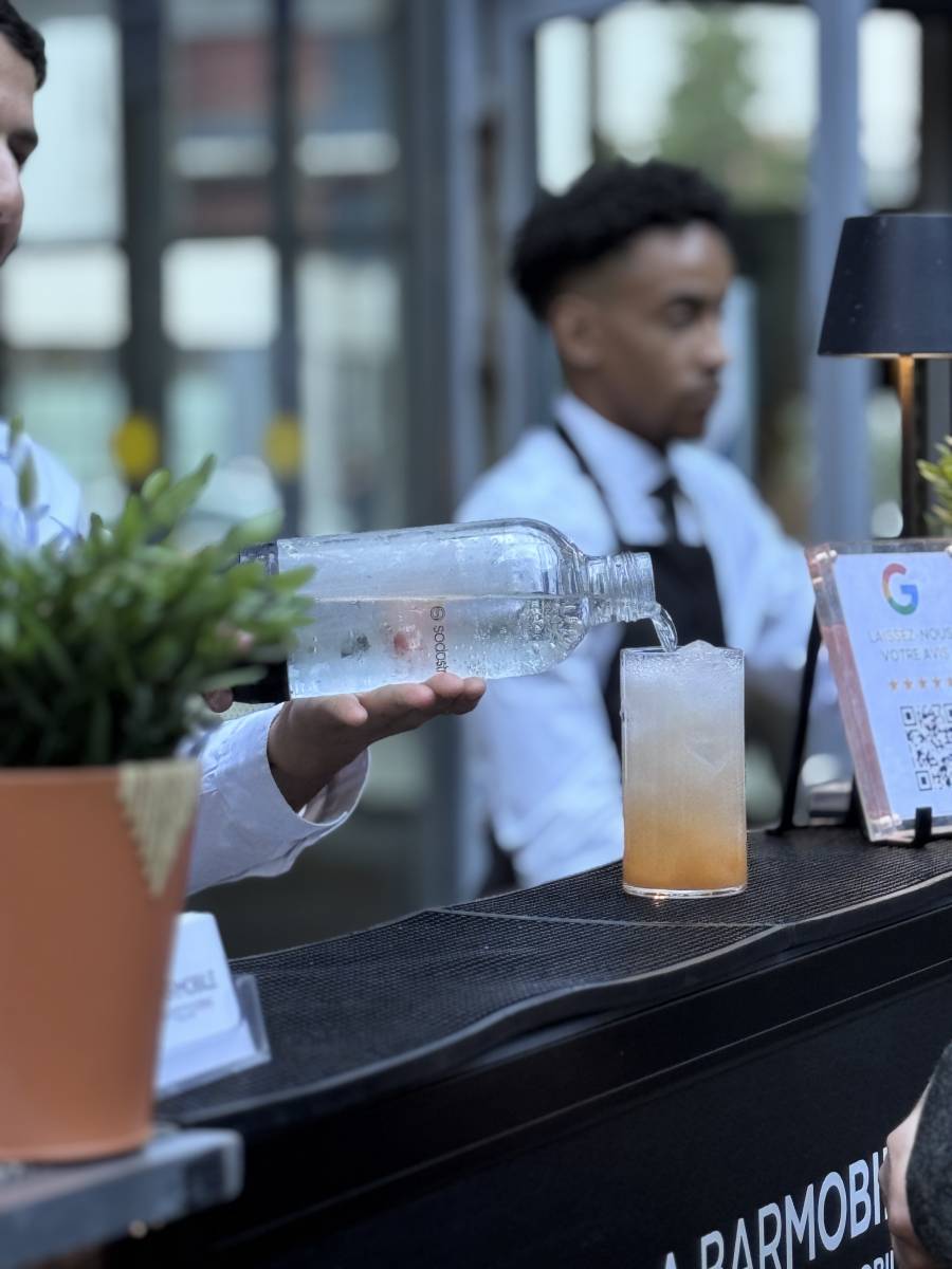 Deux barmans en action sur le bar mobile La Barmobile lors d'un événement d'entreprise