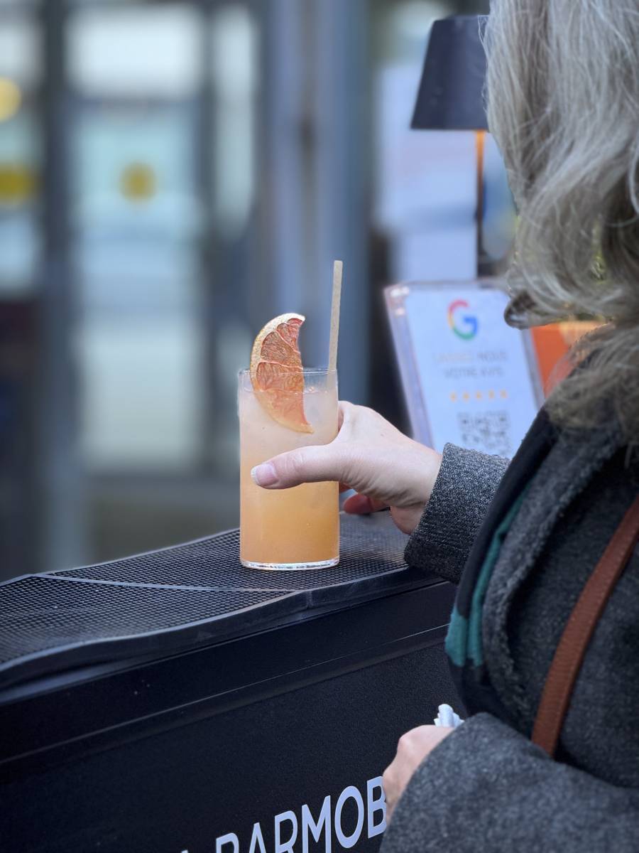  Une collaboratrice récupère son cocktail au bar mobile La Barmobile lors d'un afterwork